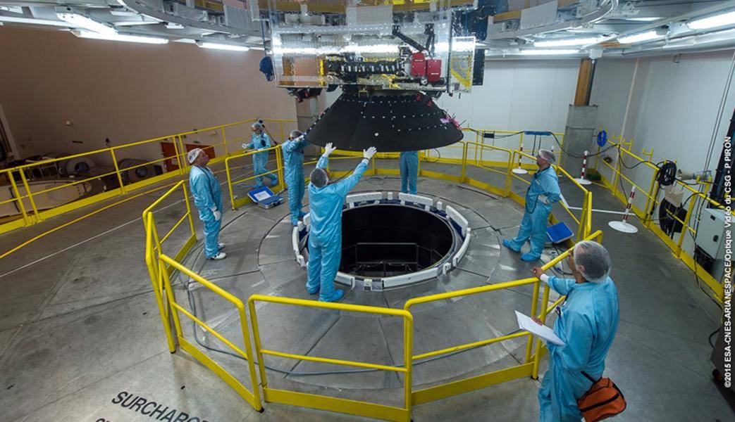 Employees are standing around and below a piece of rocket as they work on it