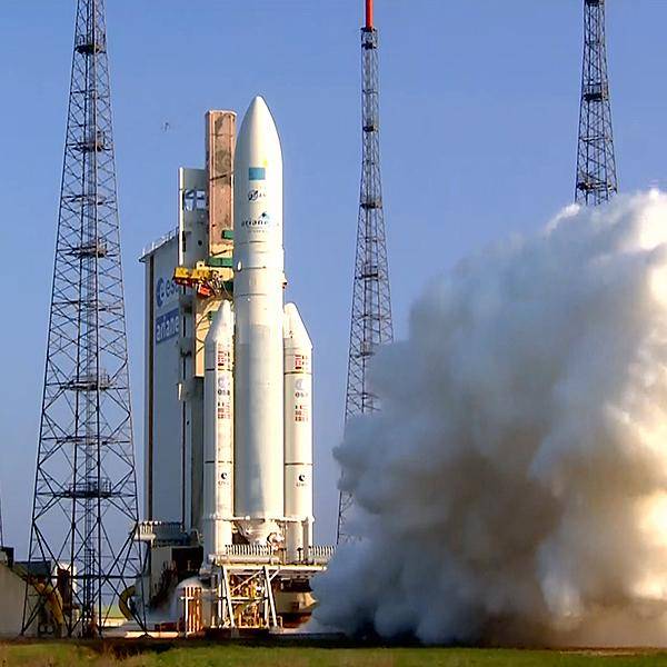 A rocket is starting to take off from its launchpad with plumes of smoke coming from the engines