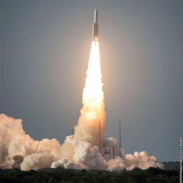 A rocket is just taking off from its launchpad with flames shooting out of its engines